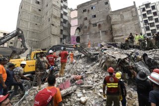 Les secours s'activent à la recherche de survivants après l'effondrement d'un immeuble à Karachi, vendredi. KEYSTONE/EPA/SHAHZAIB AKBER